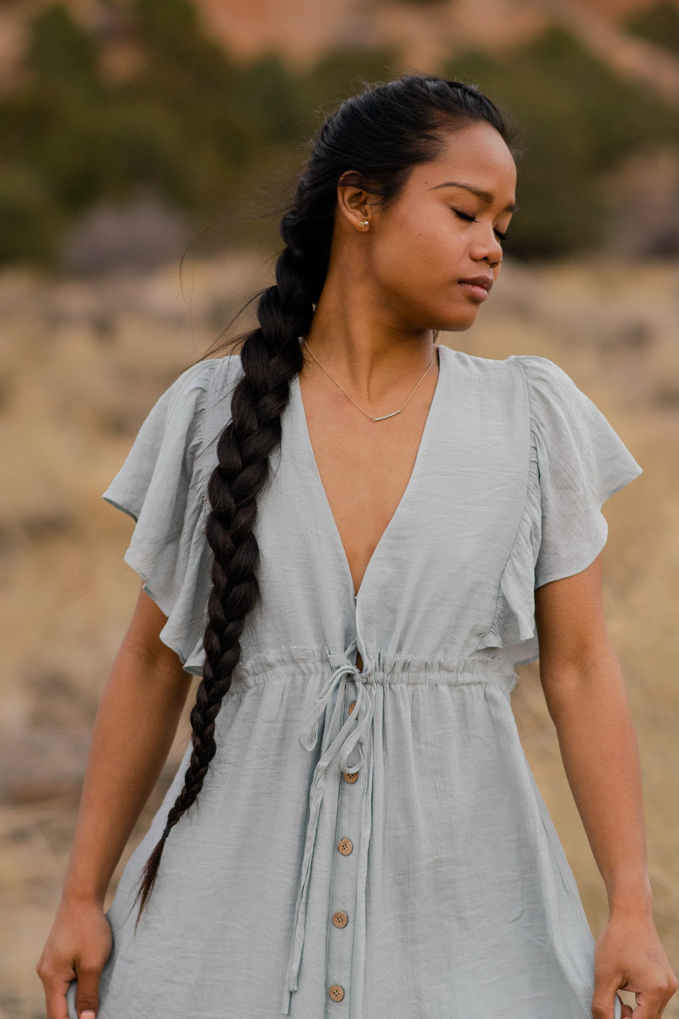 Women is in a light blue, V-neck, button down, angel sleeve, maxi dress. bella by grace co