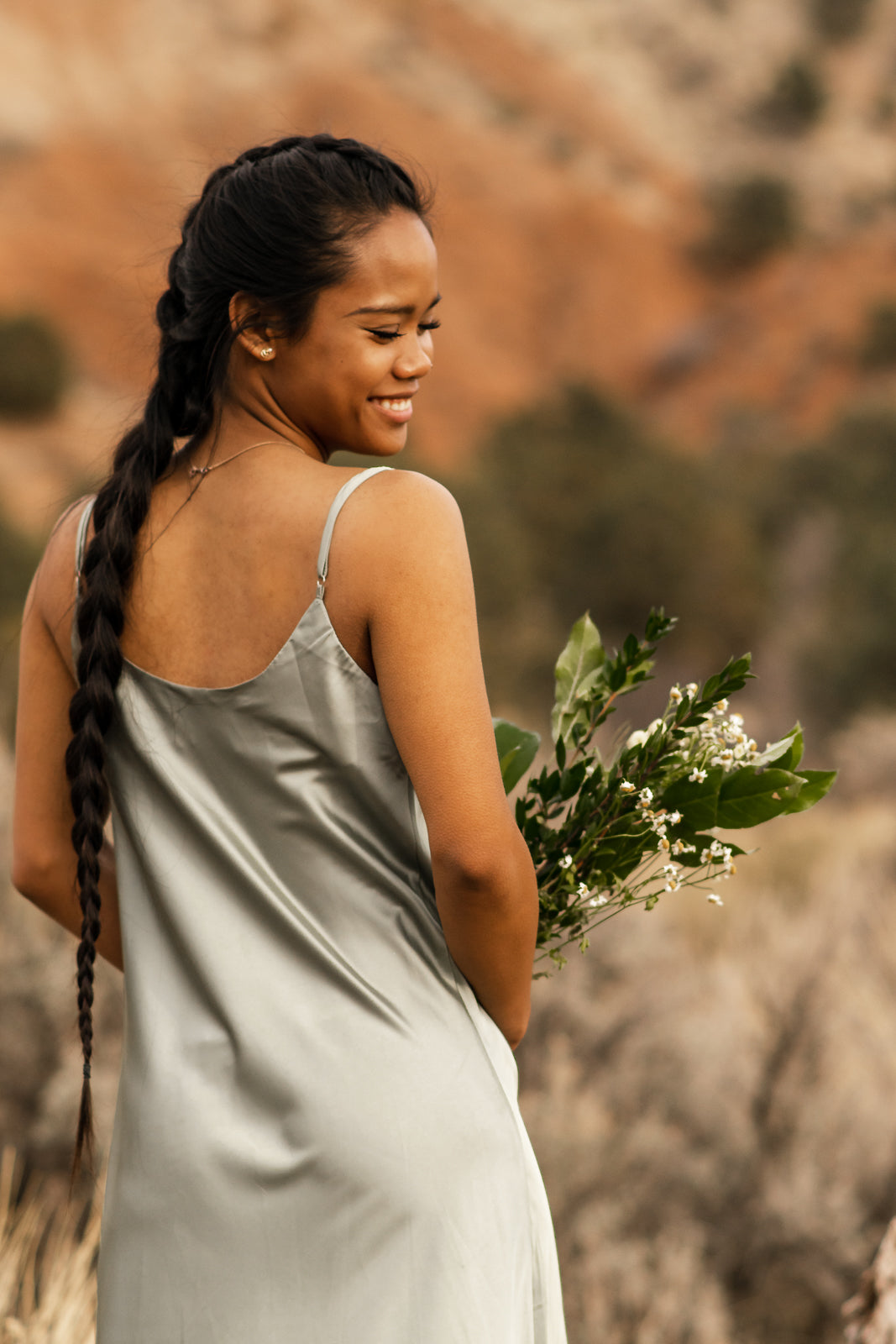  Women displaying back of satin green slip dress. bella by grace co.