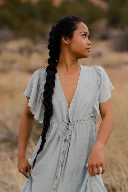  Women is in a light blue, V-neck, button down, angel sleeve, maxi dress. bella by grace co